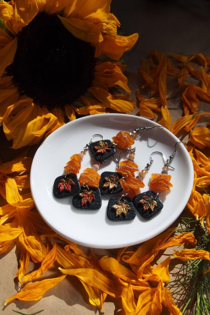 Handmade autumn earrings from polymer clay, natural amber, and sun stone beads. Adorned with black charms and colorful maple charms of them. Perfect gift for any fall jewelry lover or fan of one of a kind earrings.